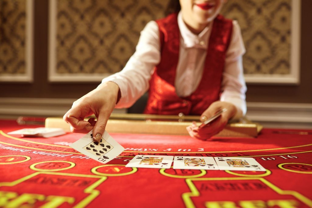 Croupier dealing cards at the Poker table.