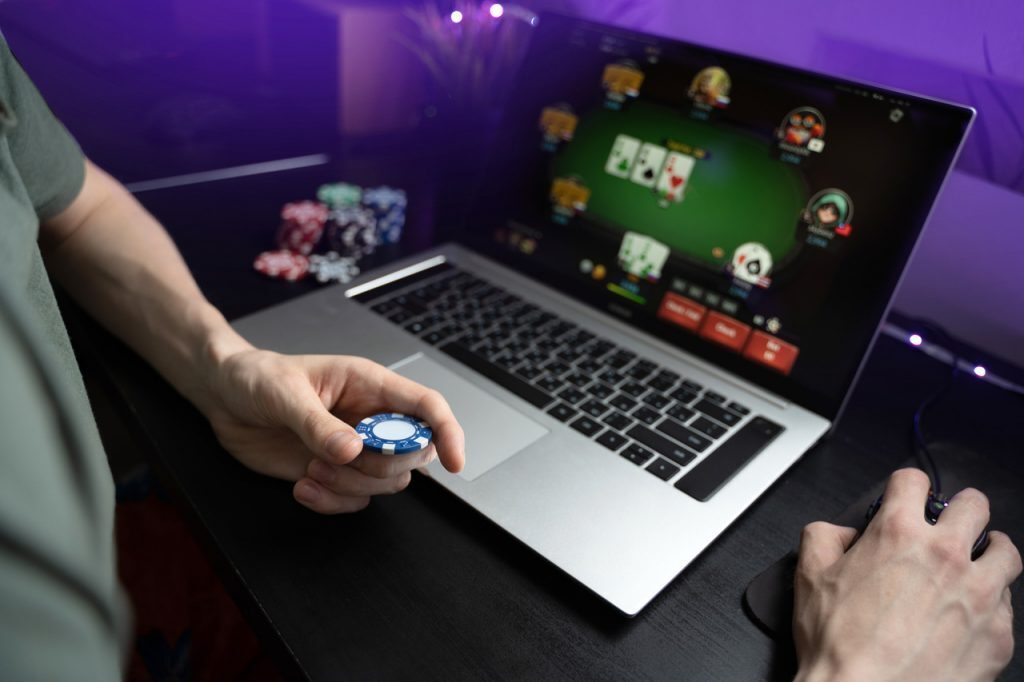 Online poker player with chip and Laptop