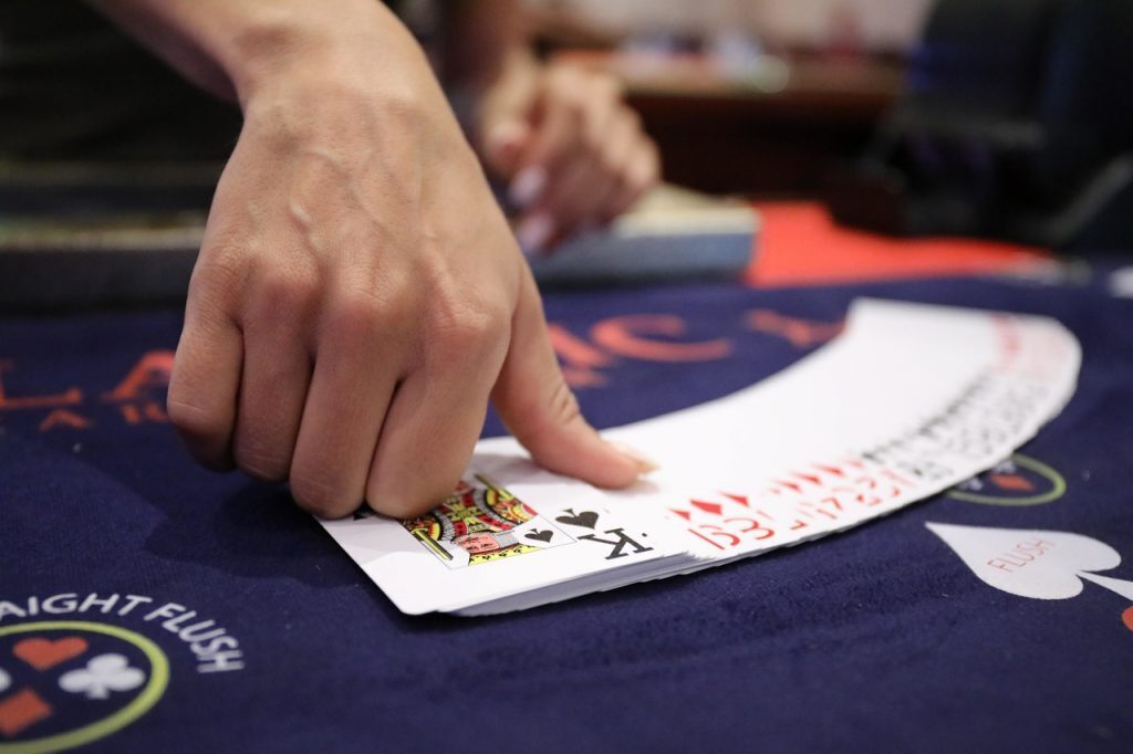 Dealer with playing cards at a casino table