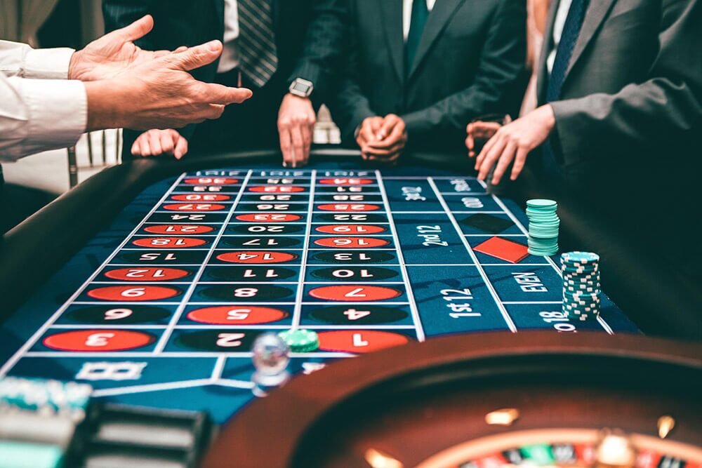Roulette table with people placing bets