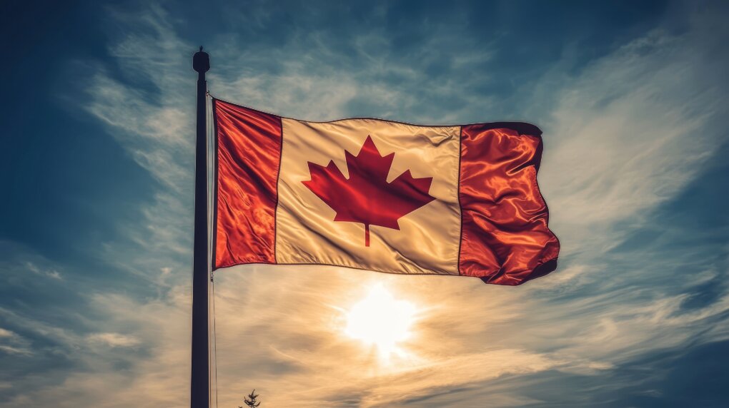 Canadian flag rippling in the breeze with backdrop of a sunset